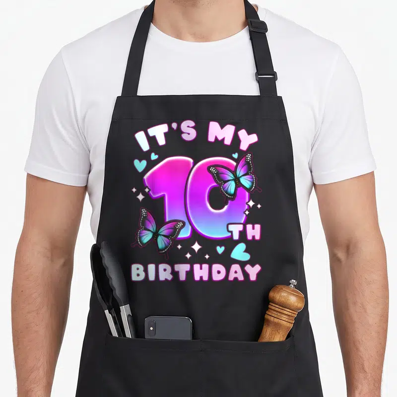 10th butterfly aprons - IT'S MY 10TH BIRTHDAY with pink blue purple butterflies hearts sparkles cartoon style — shown on a black cotton canvas apron against a white background