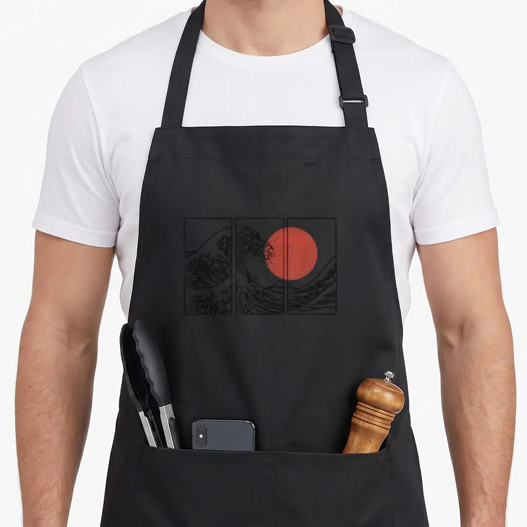 Flag japan apron - Black line art of a large wave across three panels with a red sun circle — shown on a black cotton canvas apron against a white background