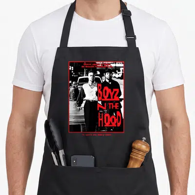 Boyz hip hop apron - Three men in black and white photo with red BOYZ N THE HOOD text and border — shown on a black cotton canvas apron against a white background