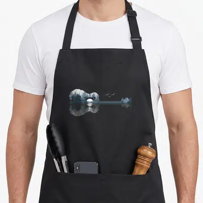 Guitar lake acoustics apron - Acoustic guitar silhouette filled with trees, sun, and three birds reflecting in water — shown on a black cotton canvas apron against a white background
