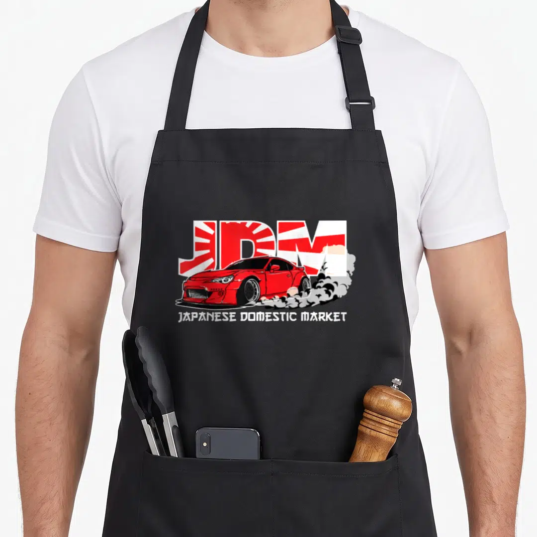 Market car apron - Red drifting car with JDM rising sun background and Japanese Domestic Market text — shown on a black cotton canvas apron against a white background