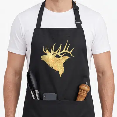 Topographical antler oak apron - Elk head silhouette filled with tan and brown topographic map contour lines — shown on a black cotton canvas apron against a white background