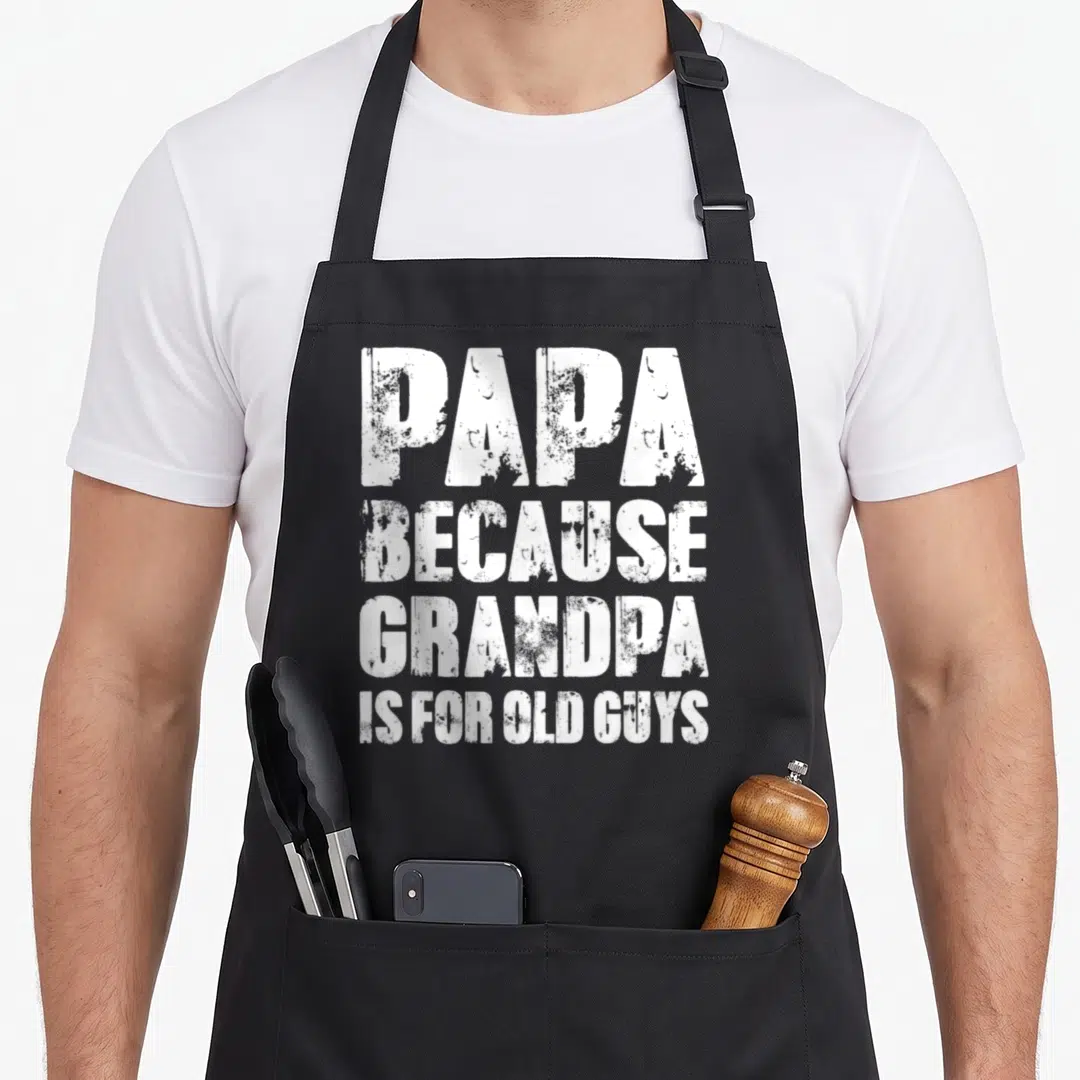 Papa grandfather grandpa apron - White distressed stacked text reading PAPA BECAUSE GRANDPA IS FOR OLD GUYS — shown on a black cotton canvas apron against a white background