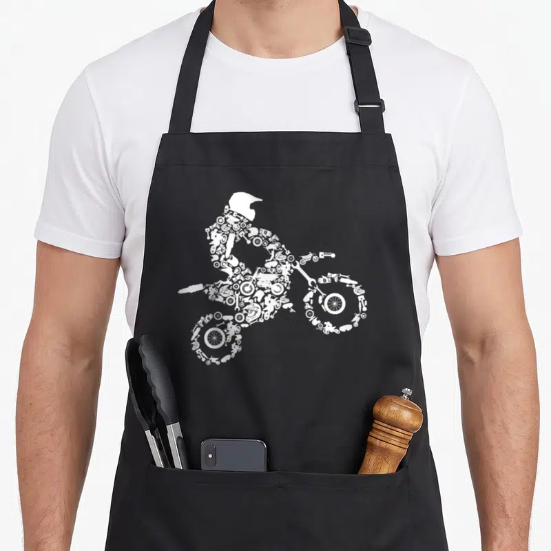 Dirt rider bike apron - White silhouette of motocross rider made of wrenches gears and tools — shown on a black cotton canvas apron against a white background
