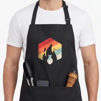 Kiln clay apron - White flame silhouette inside hexagon with red orange yellow blue white distressed stripes — shown on a black cotton canvas apron against a white background