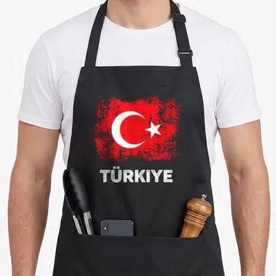 Patriot turkey apron - Distressed red flag with white crescent star and TÜRKIYE text below — shown on a black cotton canvas apron against a white background