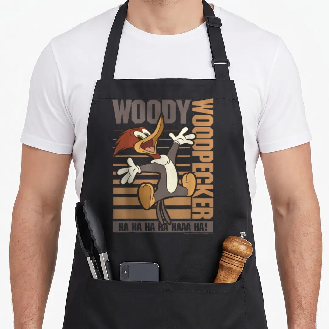 Jumping woodpecker apron - Cartoon woodpecker jumping with WOODY text and brown stripes — shown on a black cotton canvas apron against a white background