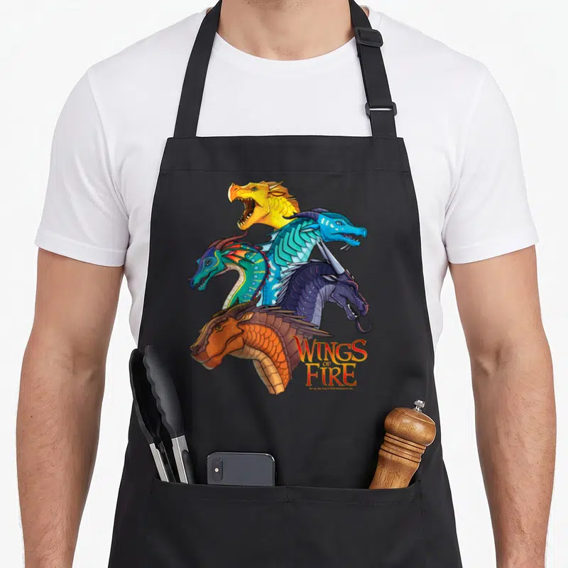 Wing fire dragon apron - Five dragon heads stacked vertically with Wings of Fire logo in stylized font — shown on a black cotton canvas apron against a white background