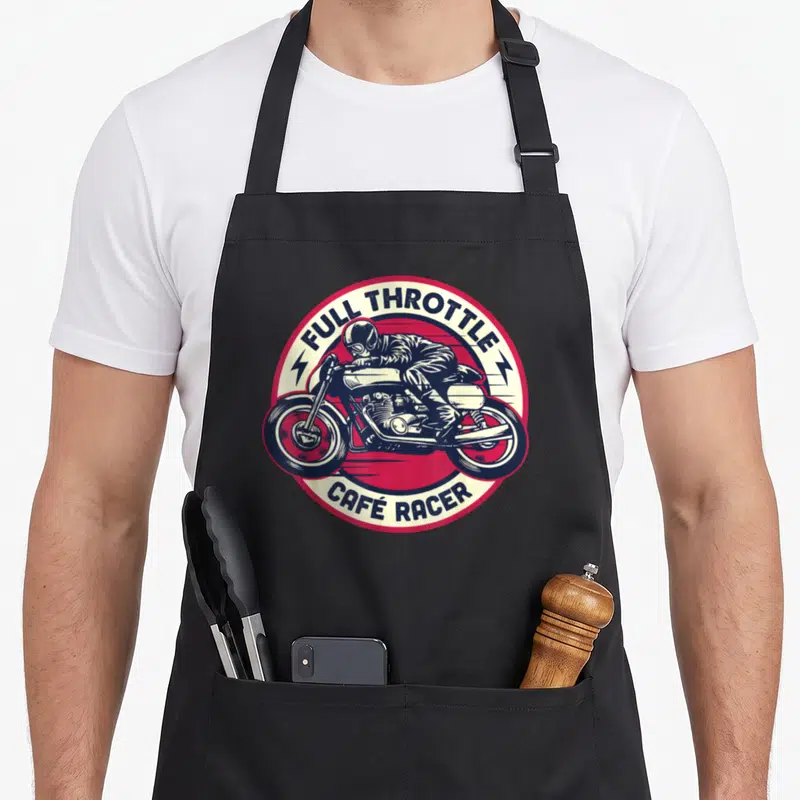 Racer motorcycle apron - Retro circular emblem with motorcyclist and full throttle café racer text in blue red and cream — shown on a black cotton canvas apron against a white background