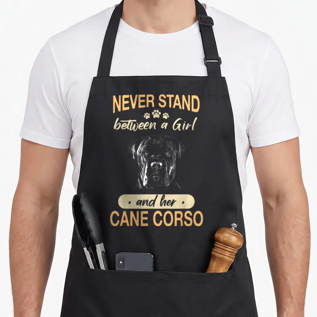 Corso italiano cane apron - Distressed text Never Stand Between a Girl and Her Cane Corso above a dog head sketch — shown on a black cotton canvas apron against a white background