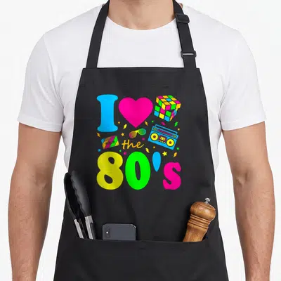 Dress 80s apron - Neon I heart the 80s graphic with boombox cassette and Rubik cube — shown on a black cotton canvas apron against a white background