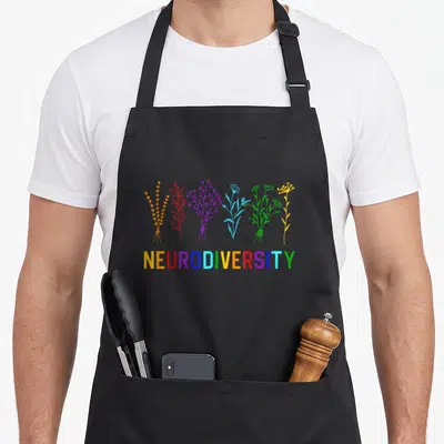 Flower rainbow apron - Six colored line art flower bundles above multicolored NEURODIVERSITY text — shown on a black cotton canvas apron against a white background