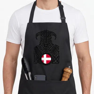 Denmark viking apron - Black Celtic knot viking silhouette with circular red and white Danish flag centered below — shown on a black cotton canvas apron against a white background