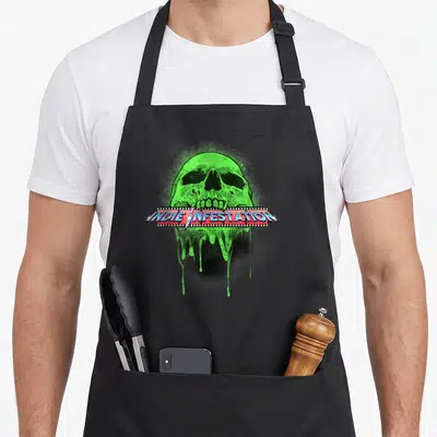 Infestation indie apron - Green skull with slime and film strip reading INDIE INFESTATION in blue and red — shown on a black cotton canvas apron against a white background