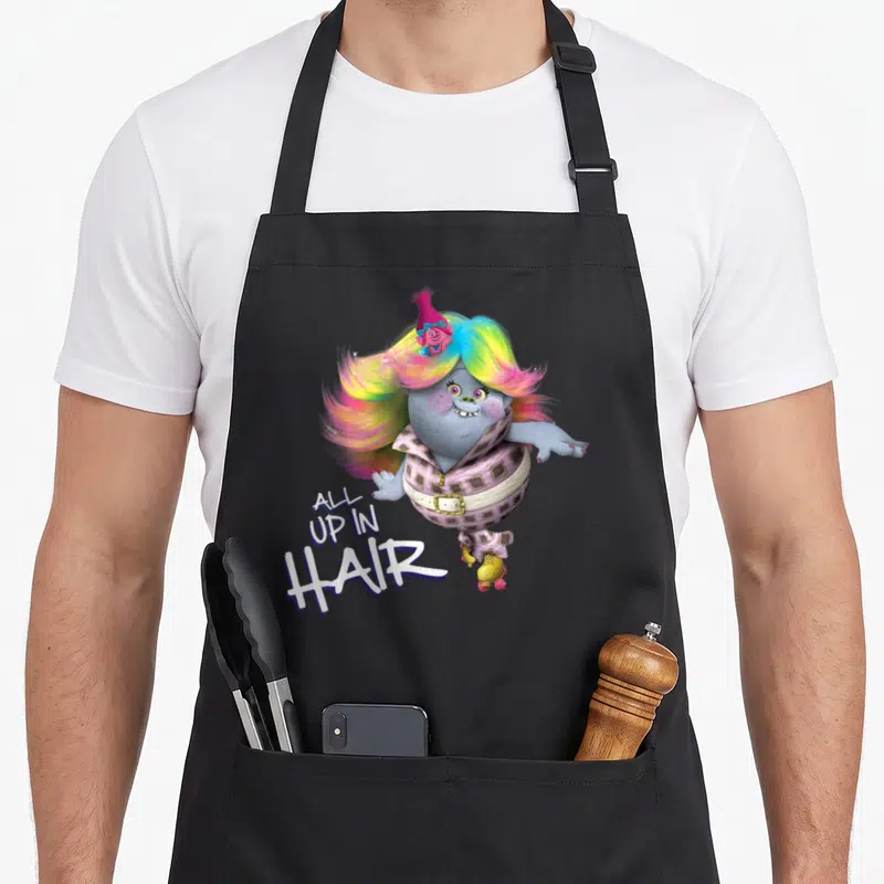 Troll hair apron - Grey Troll with rainbow hair and checkered outfit wearing roller skates with text All Up in Hair — shown on a black cotton canvas apron against a white background