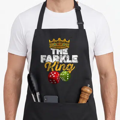 Farkle king apron - Gold crown above THE FARKLE King text with one red and one green die below — shown on a black cotton canvas apron against a white background