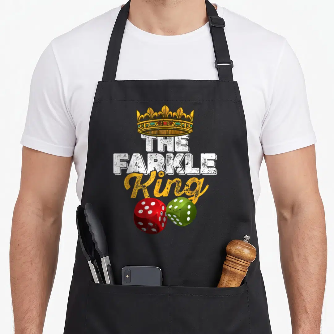 Farkle king apron - Gold crown above THE FARKLE King text with one red and one green die below — shown on a black cotton canvas apron against a white background