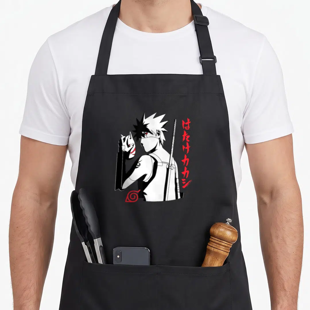 Shippuden anbu anime apron - Kakashi Hatake holding a fox mask with vertical red Japanese text and spiral symbol — shown on a black cotton canvas apron against a white background