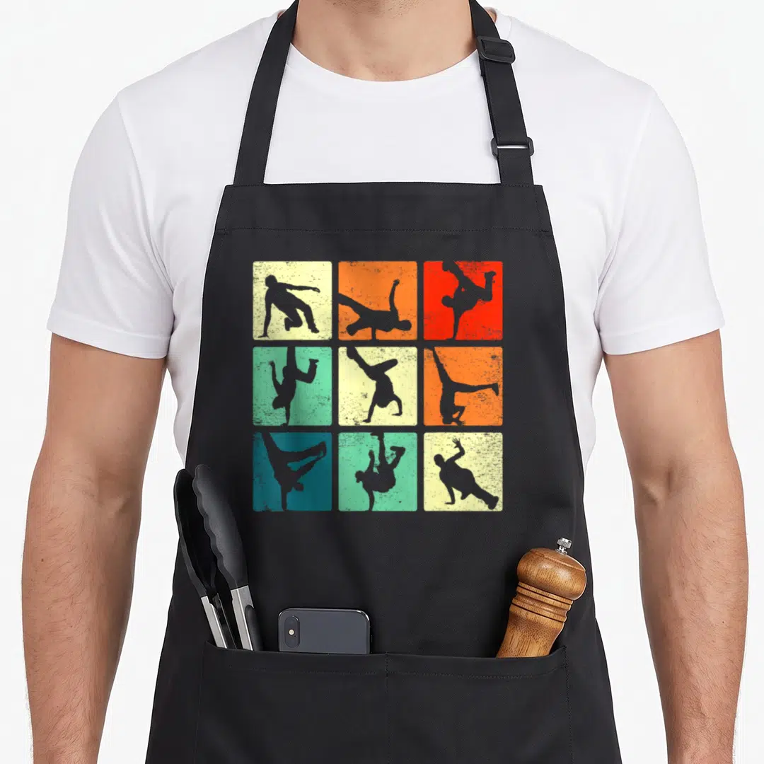 Break hip apron - Nine square panels showing grey break dancer silhouettes in retro vintage poses on textured — shown on a black cotton canvas apron against a white background