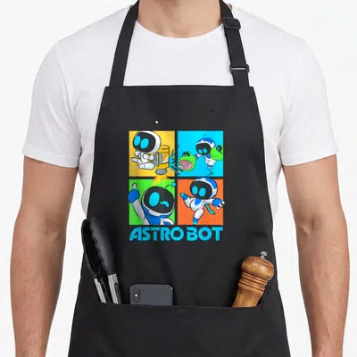 Bot video game apron - Four colorful robot panels with blue ASTRO BOT text below — shown on a black cotton canvas apron against a white background