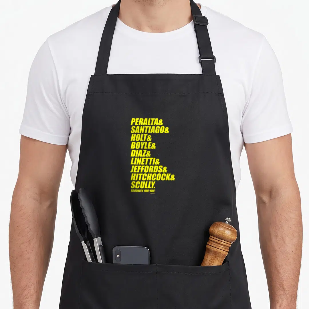 Ampersand brooklyn apron - Yellow stacked surnames Peralta Santiago Holt Boyle Diaz Linetti Jeffords Hitchcock Scully — shown on a black cotton canvas apron against a white background
