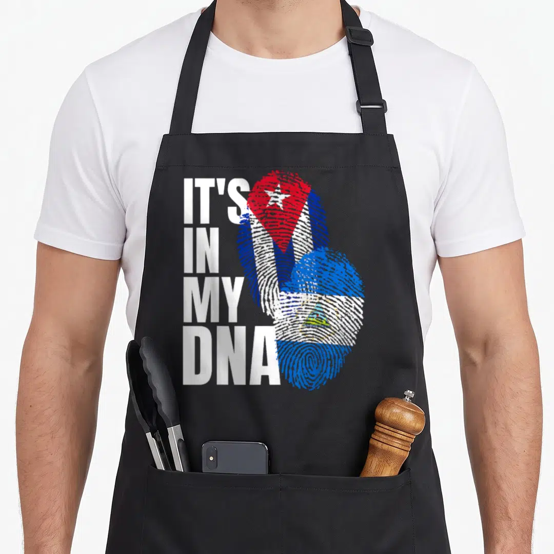 Nicaraguan cuban heritage aprons - Stacked IT'S IN MY DNA text beside two overlapping fingerprints filled with Cuban — shown on a black cotton canvas apron against a white background
