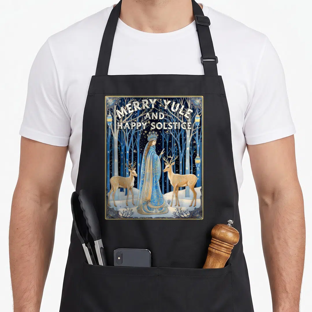 Yule merry christmas apron - Merry Yule and Happy Solstice text above crowned woman and two deer in blue gold art — shown on a black cotton canvas apron against a white background