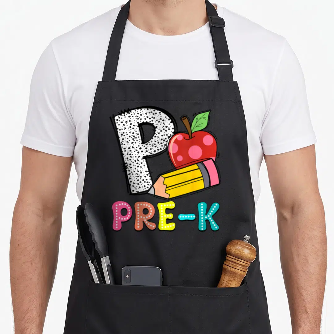 Pre pencil teacher apron - Polka dot letter P with red apple and yellow pencil above colorful PRE-K text — shown on a black cotton canvas apron against a white background