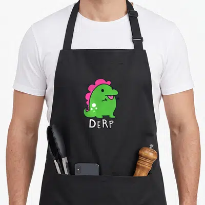 Derpy dinosaur apron - Green cartoon dinosaur with pink crest and white DERP text below — shown on a black cotton canvas apron against a white background