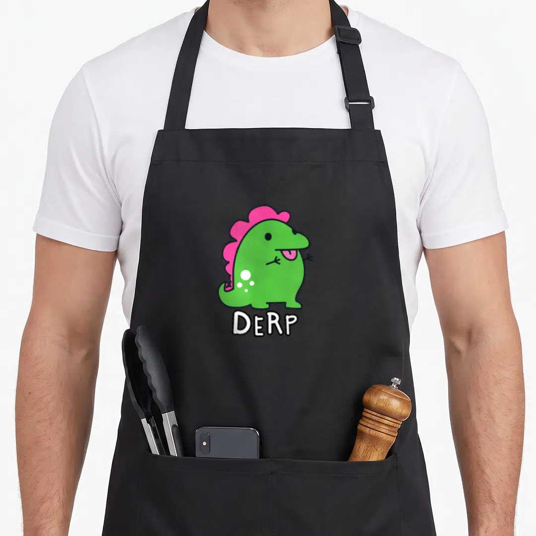 Derpy dinosaur apron - Green cartoon dinosaur with pink crest and white DERP text below — shown on a black cotton canvas apron against a white background