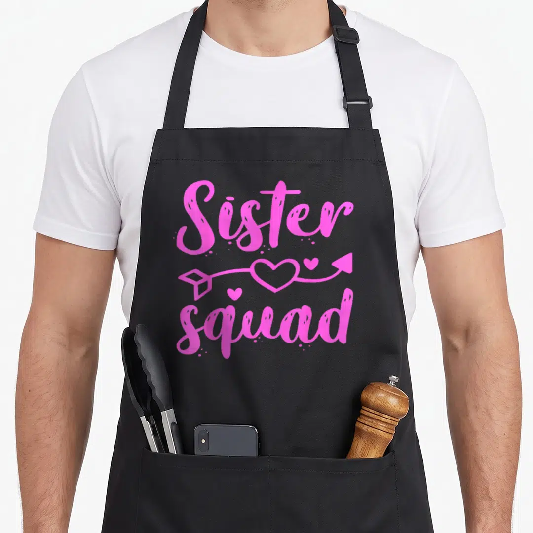 Gang family aprons - Pink Sister squad text with heart arrow graphic — shown on a black cotton canvas apron against a white background