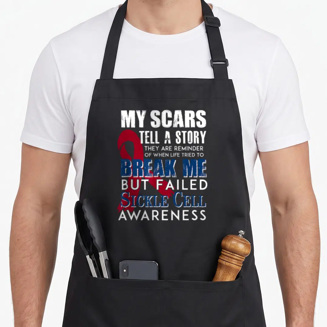 Sickle story of the apron - Red ribbon behind stacked white and distressed blue text reading My Scars Tell A Story — shown on a black cotton canvas apron against a white background