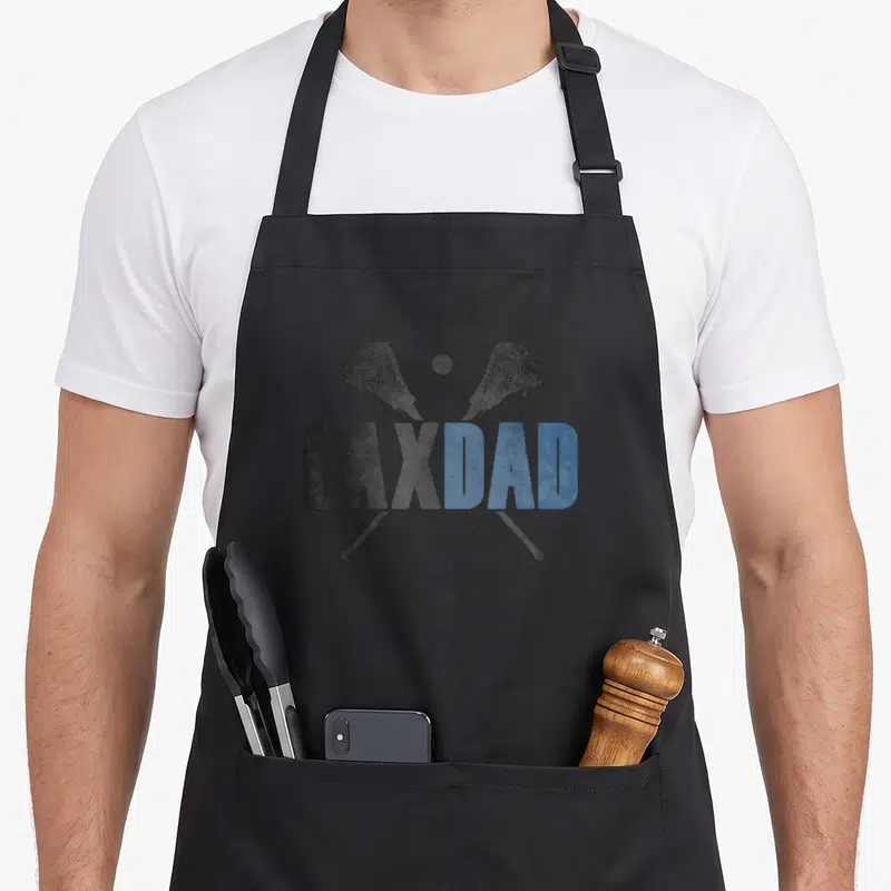Lax founder apron - Crossed dark grey and blue lacrosse sticks with ball above LAXDAD text in distressed font — shown on a black cotton canvas apron against a white background