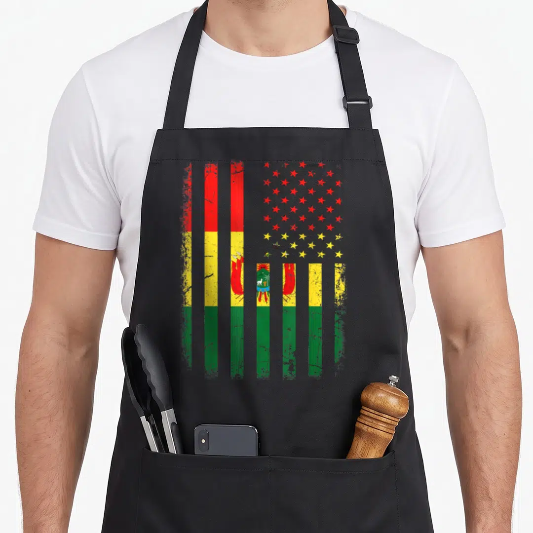 Root bolivia american flag apron - Vertical red yellow green stripes with distressed stars and coat of arms — shown on a black cotton canvas apron against a white background