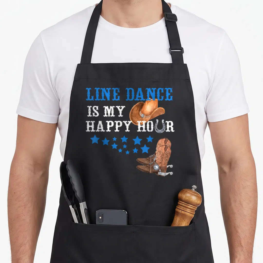 Hour line apron - Stacked text Line Dance Is My Happy Hour with cowboy hat boots and stars — shown on a black cotton canvas apron against a white background