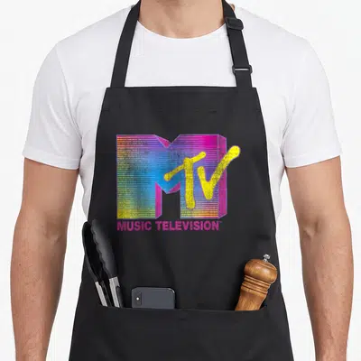 Mtv crew apron - Retro MTV logo with pink yellow blue M and MUSIC TELEVISION text — shown on a black cotton canvas apron against a white background