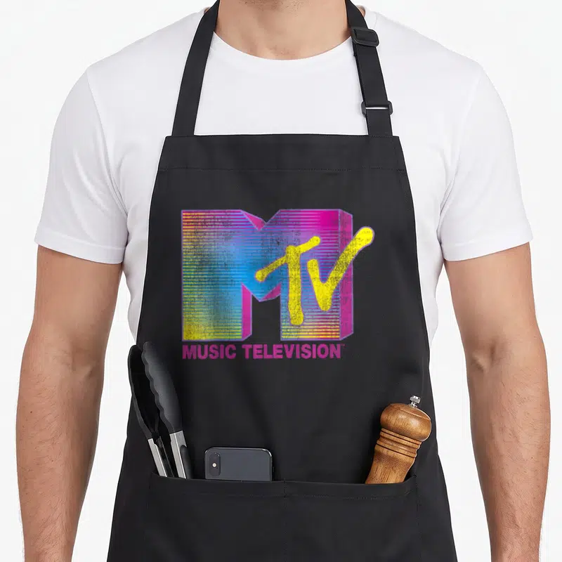 Mtv crew apron - Retro MTV logo with pink yellow blue M and MUSIC TELEVISION text — shown on a black cotton canvas apron against a white background