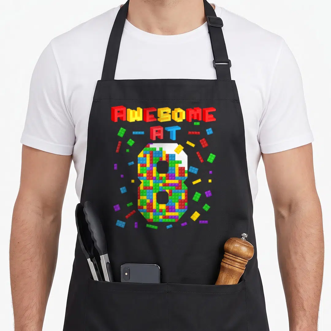 8th building aprons - Colorful brick number 8 and AWESOME AT 8 text in 3D digital style — shown on a black cotton canvas apron against a white background