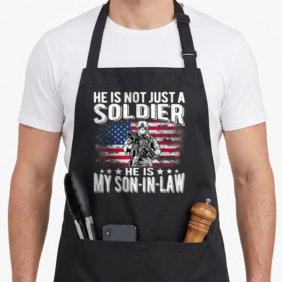 Son military apron - Soldier holding rifle before distressed flag with text about son-in-law — shown on a black cotton canvas apron against a white background