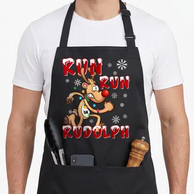 Rudolph holiday christmas aprons - Sprinting reindeer with 5K bib and RUN RUN RUDOLPH text surrounded by snowflakes — shown on a black cotton canvas apron against a white background