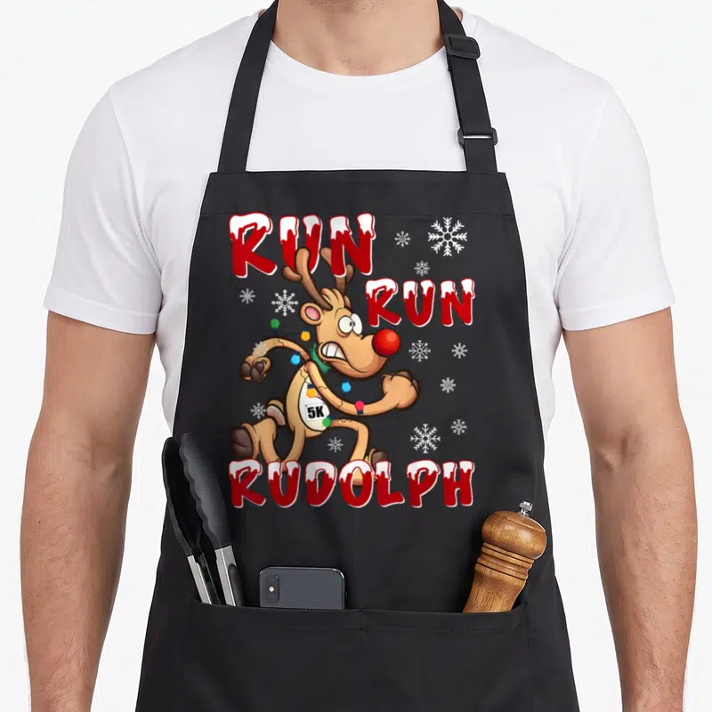 Rudolph holiday christmas aprons - Sprinting reindeer with 5K bib and RUN RUN RUDOLPH text surrounded by snowflakes — shown on a black cotton canvas apron against a white background