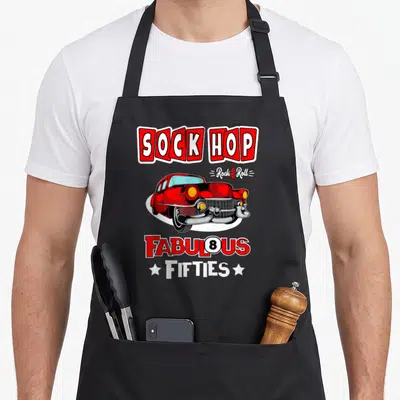 Costume rockabilly apron - Red classic car with SOCK HOP and FABULOUS FIFTIES text in cartoon style — shown on a black cotton canvas apron against a white background