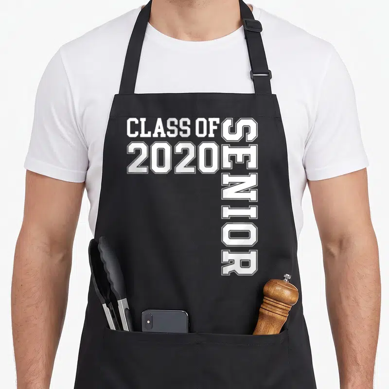 Senior class school graduation apron - White CLASS OF 2020 SENIOR text with vertical SENIOR layout on grey background — shown on a black cotton canvas apron against a white background
