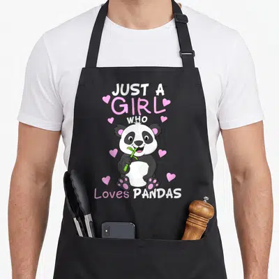 Pandas but just apron - Cartoon panda holding green bamboo with stacked text JUST A GIRL WHO Loves PANDAS and pink — shown on a black cotton canvas apron against a white background