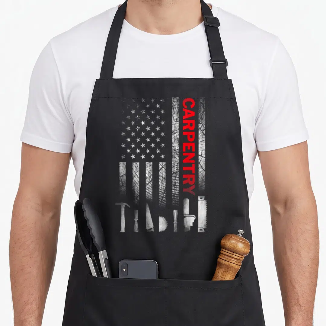 Tool carpentry apron - Distressed white USA flag with vertical red CARPENTRY text and white tool silhouettes along — shown on a black cotton canvas apron against a white background