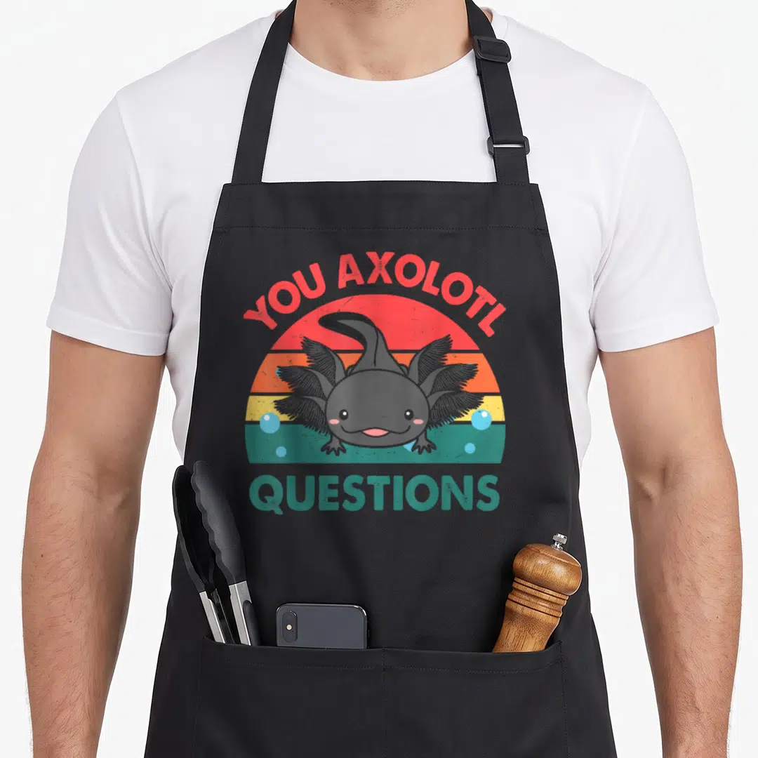 Cute question crazy axolotl man apron - Grey axolotl in front of red orange yellow teal striped sun with YOU AXOLOTL — shown on a black cotton canvas apron against a white background
