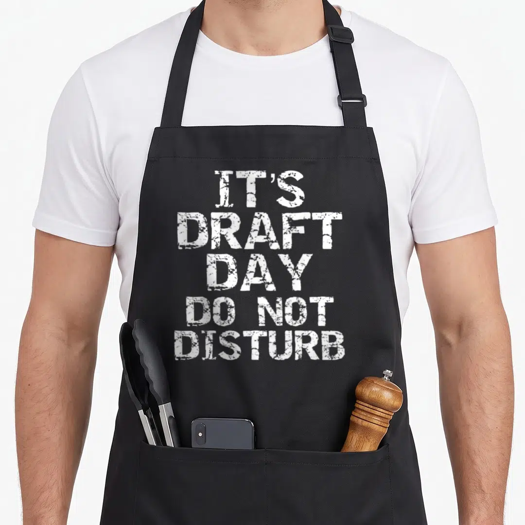 Disturb football apron - White stacked IT'S DRAFT DAY DO NOT DISTURB text on grey background — shown on a black cotton canvas apron against a white background