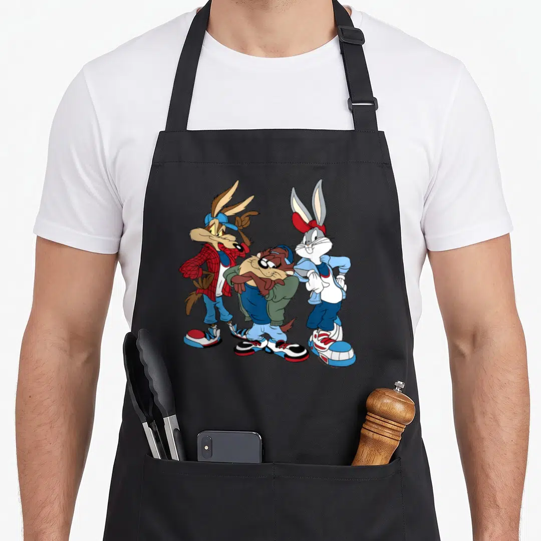 Wiley looney tune apron - Three cartoon characters in red and blue streetwear standing side-by-side — shown on a black cotton canvas apron against a white background