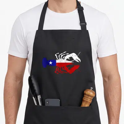 Crawfish southern aprons - Distressed lobster silhouette filled with blue white and red Texas flag pattern — shown on a black cotton canvas apron against a white background