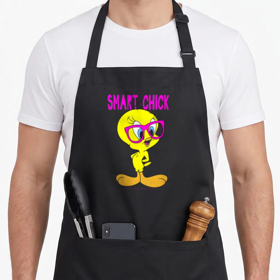 Bird smart apron - SMART CHICK text above yellow bird in pink glasses cartoon print — shown on a black cotton canvas apron against a white background